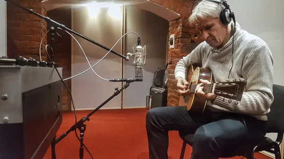 A guitarist recording acoustic guitar