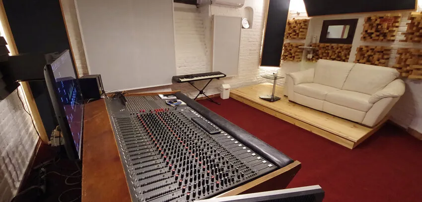 The control room with the console, keyboards and a white sofa on a raised floor