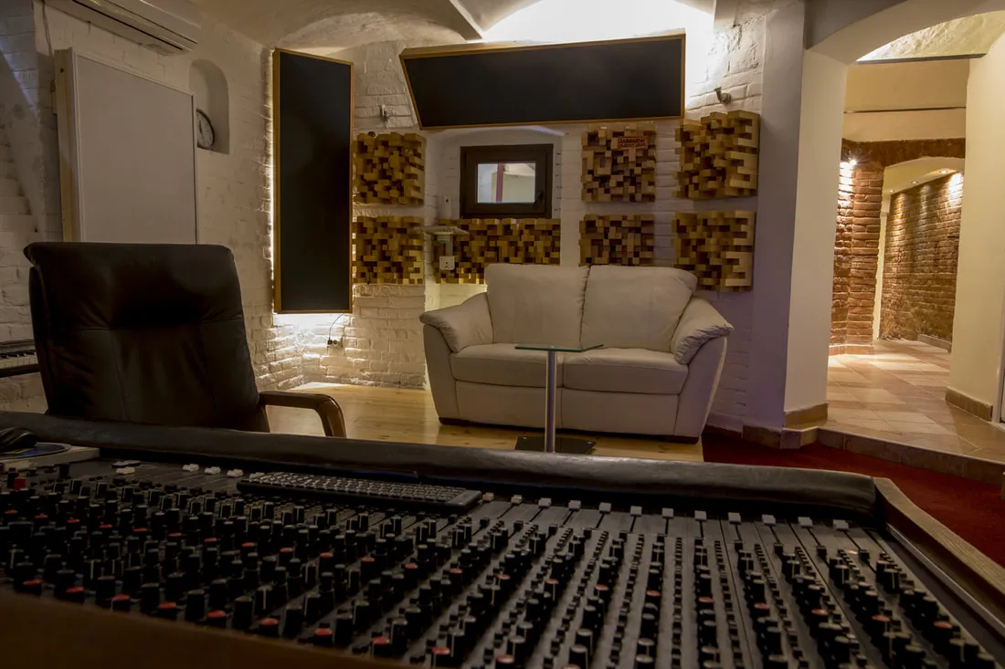 The mixing console in the control room, with the sofa behind it