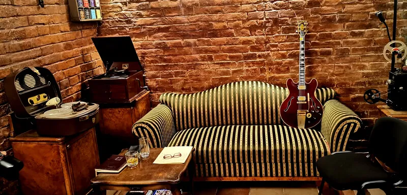 The lounge with a striped 19th century sofa and red brick walls