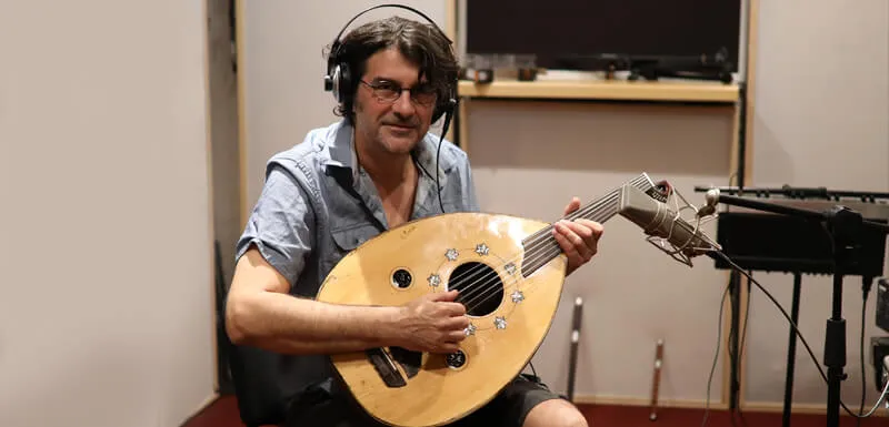 An oud player recording in the studio