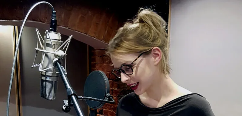 A voice actor at the microphone in the recording room